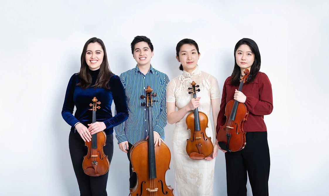 Asaka Quartet, three women and one man standing in a line holding their string instruments and smiling.