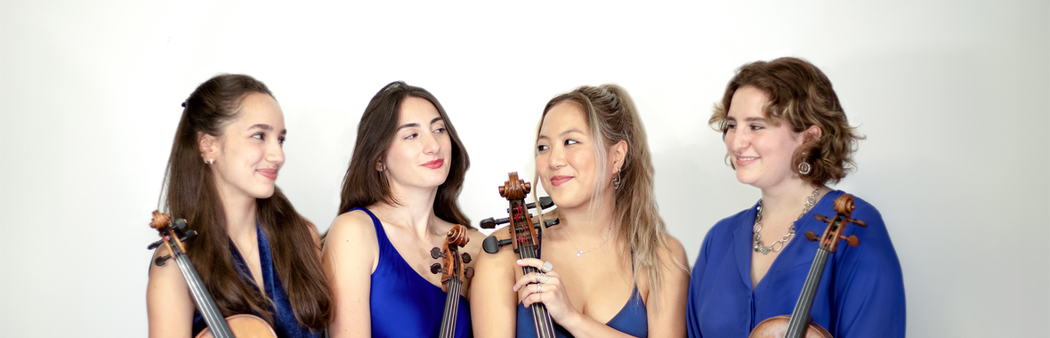 Four young women from Fiora Quartet standing together dressed in purple and holding their instruments.