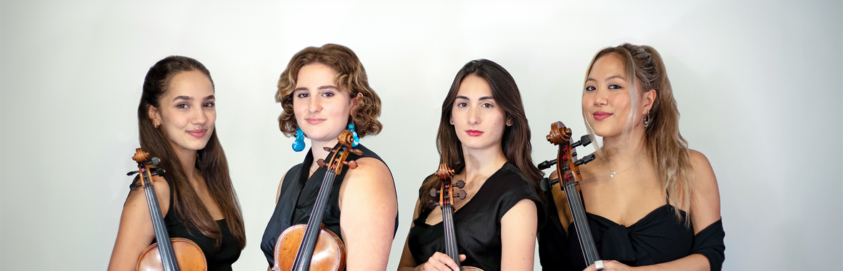 Four young women from Fiora Quartet standing together dressed in black and holding their instruments.
