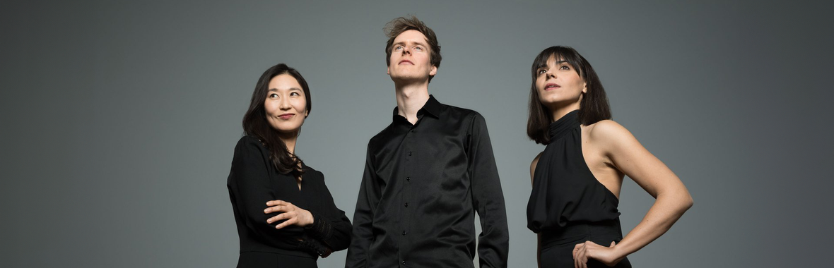 Man and two women from Quantum Clarinet Trio wearing black and looking away from the camera.