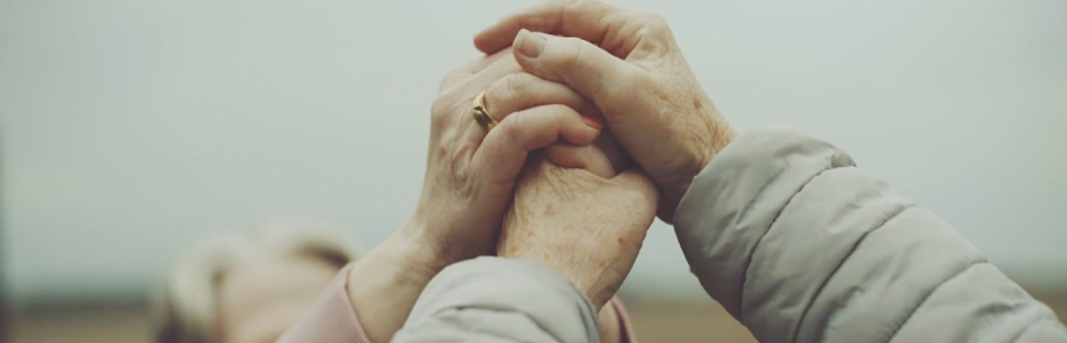 Two people holding both of their hands together.