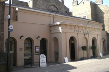 Sand coloured building with several archways.