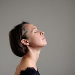 Juliet Fraser closing her eyes, her head is turned upwards.