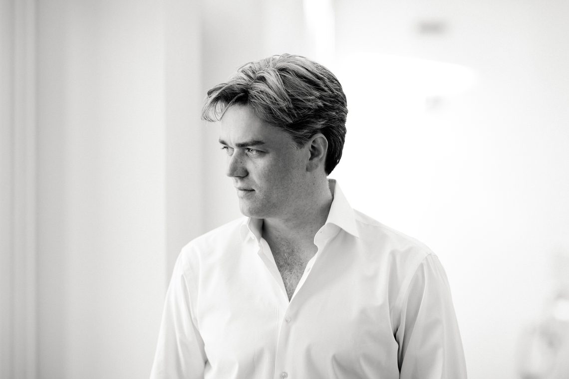 black and white image of a man with short hair wearing a white shirt