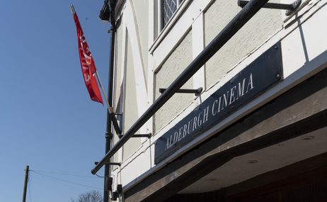Exterior view of Aldeburgh Cinema with a red festival flag.