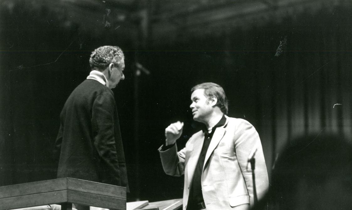 black and white image of two men talking.