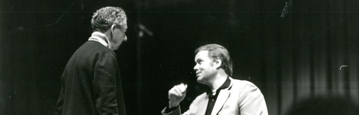 black and white image of two men talking.