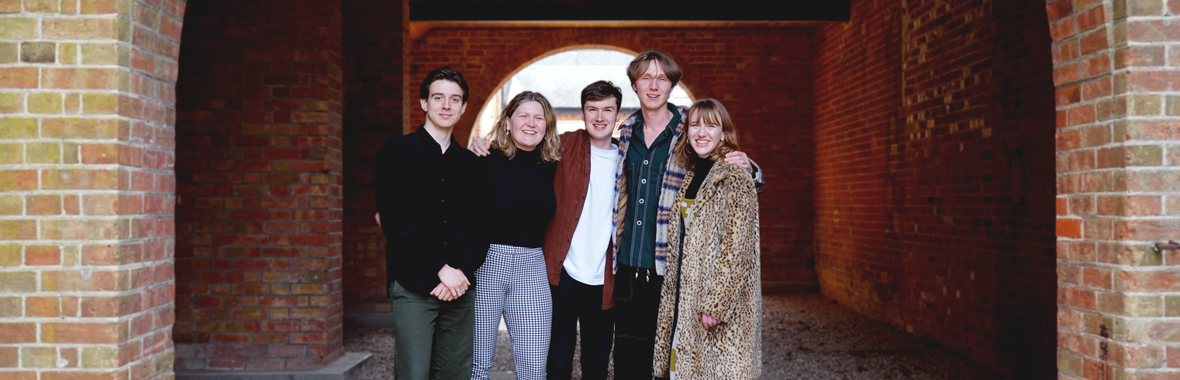 Ensemble Renard standing together in an archway smiling.