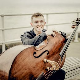 Man sitting and smiling with a double bass