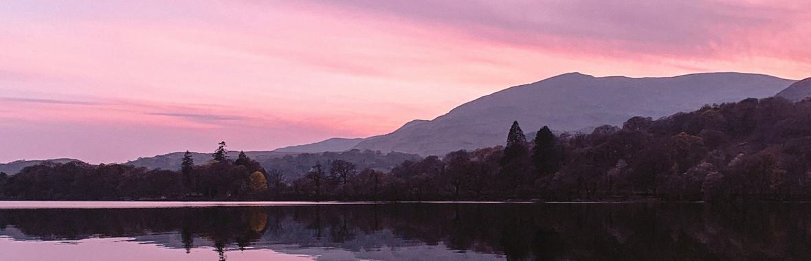 Lake and hillside in a purple sunset