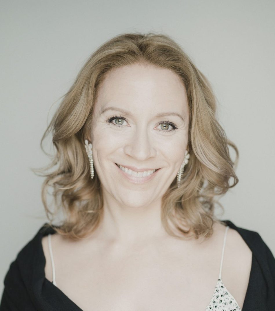 Woman with dark blond hair, wearing a black shawl and smiling.