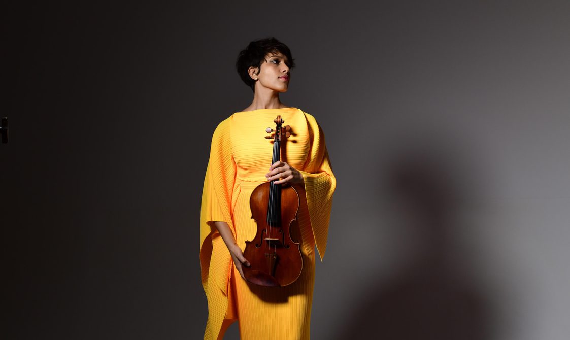 Woman wearing a bright yellow dress holding a viola