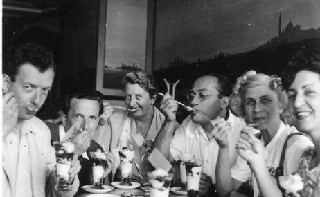 black and white image of a group of performers sitting at a coffee table.