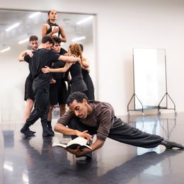 Group of dancers posing in a rehearsal studio.
