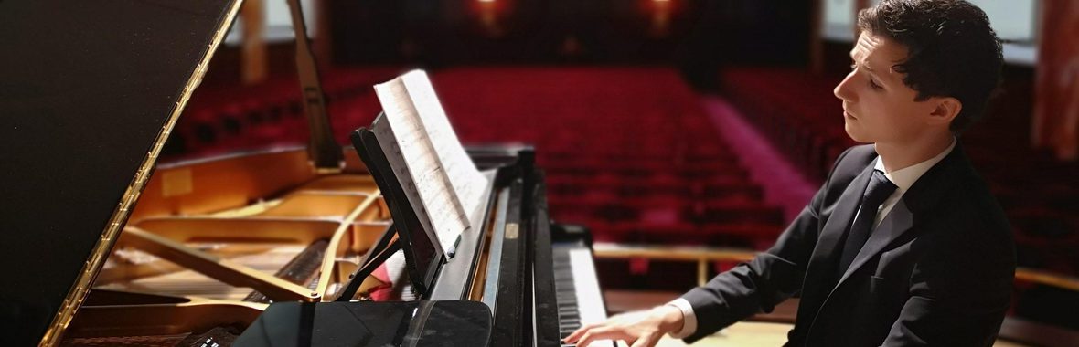 Man on a stage playing the piano.