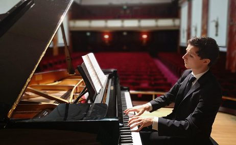 Man on a stage playing the piano.