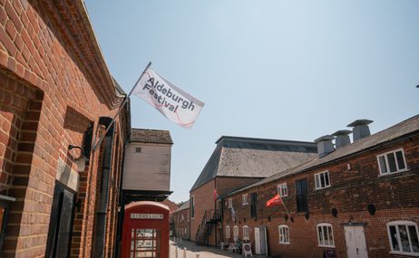 Aldeburgh Festival flag flying from a brownstone building.