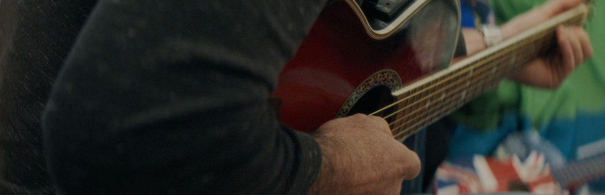 A close up of a hand strumming a guitar