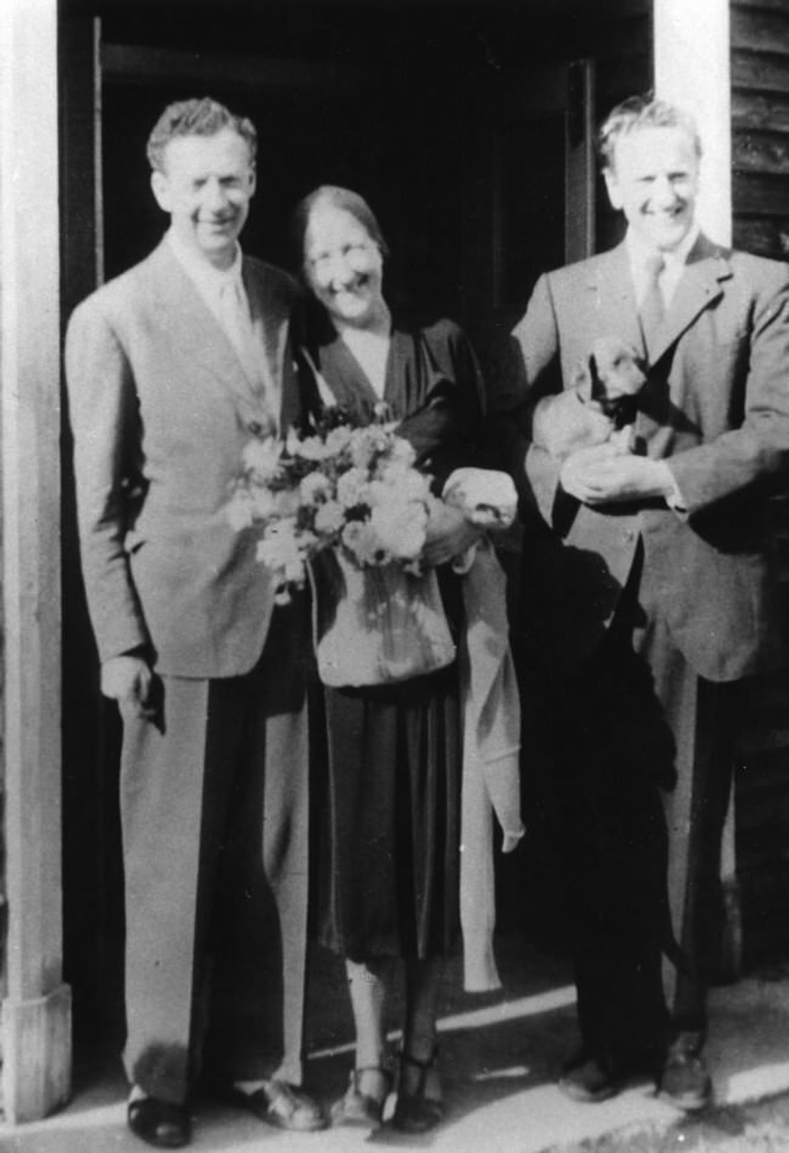 Black and white image of three people in a doorway