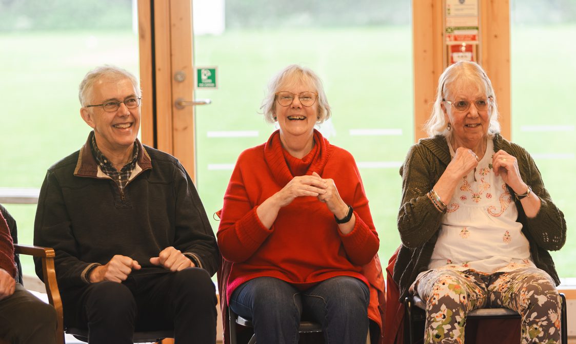 man and two women sitting together and laughing