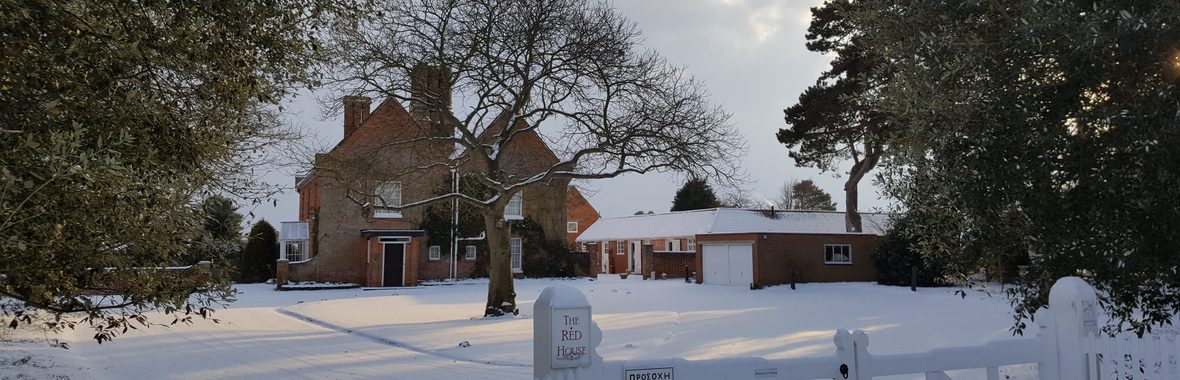 The outside of The Red House and Garden covered in snow.