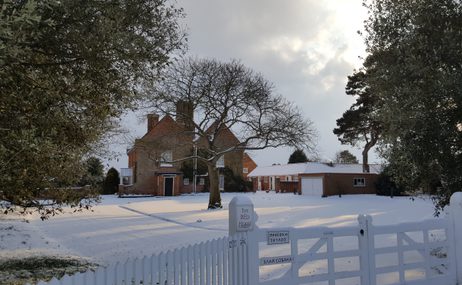 The outside of The Red House and Garden covered in snow.