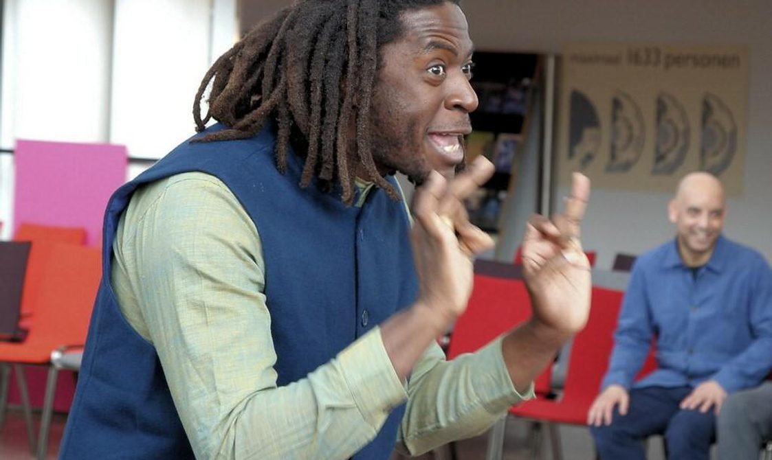 A man smiling and gesturing with his hands.