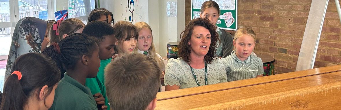 A women playing piano as a group of children watch