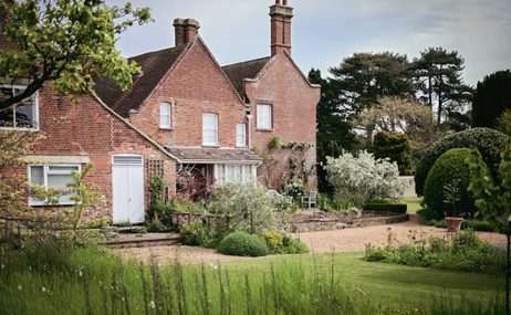 The Red House, a 17th century farmhouse in a lush, green garden.