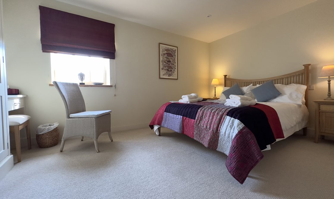 Interior view of bedroom with kind size bed and chair