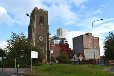 Church in a city setting, with other buildings surrounding it.