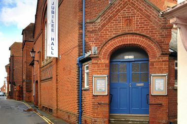 Traditional red brick building with old wooden double blue doors.
