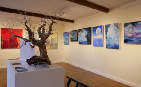 A picture of the gallery, with a small tree piece in the foreground.