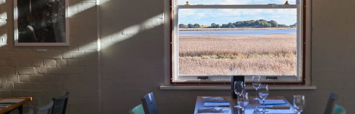 A table at the River View cafe, with a window looking out to the reedbeds and river.