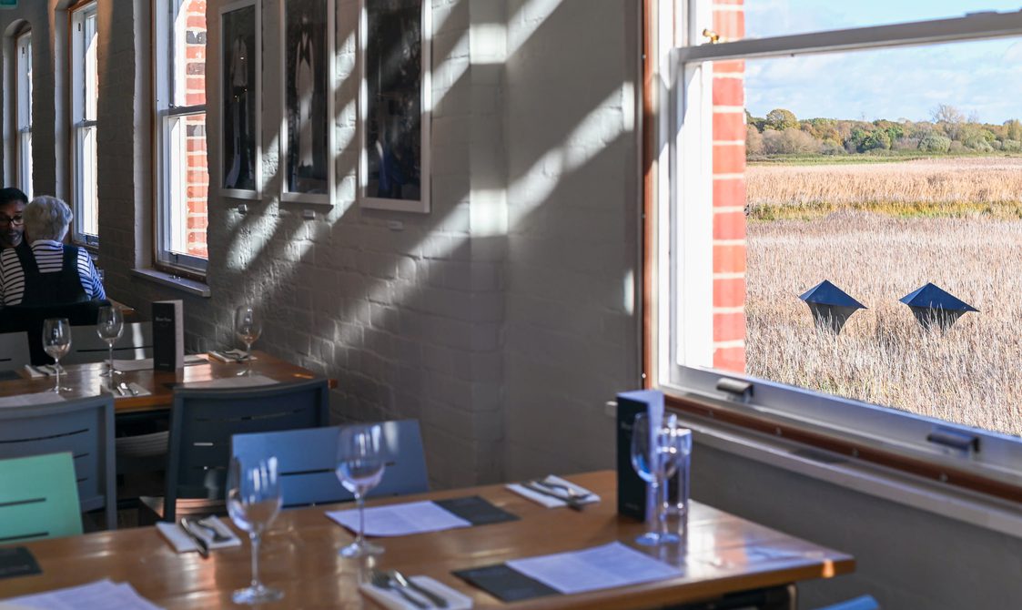A table at the river view cafe with a window looking out to the reedbeds.