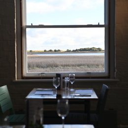 A table at the River View restaurant, with a window looking out to the reedbeds and river.