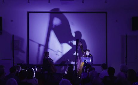 Silhouette of musicians playing instruments onstage.