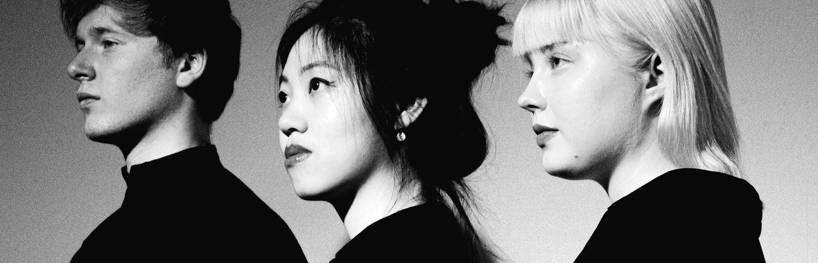 Paddington Trio, one man and two women standing side on in black and white.