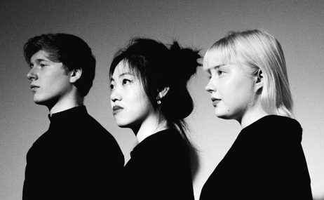 Paddington Trio, one man and two women standing side on in black and white.