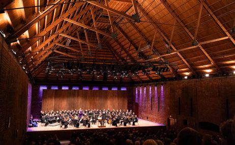 Orchestra onstage at Snape Maltings, with purple backlights.