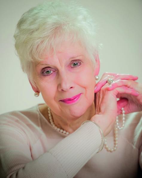 Woman with short white hair looking at the camera.