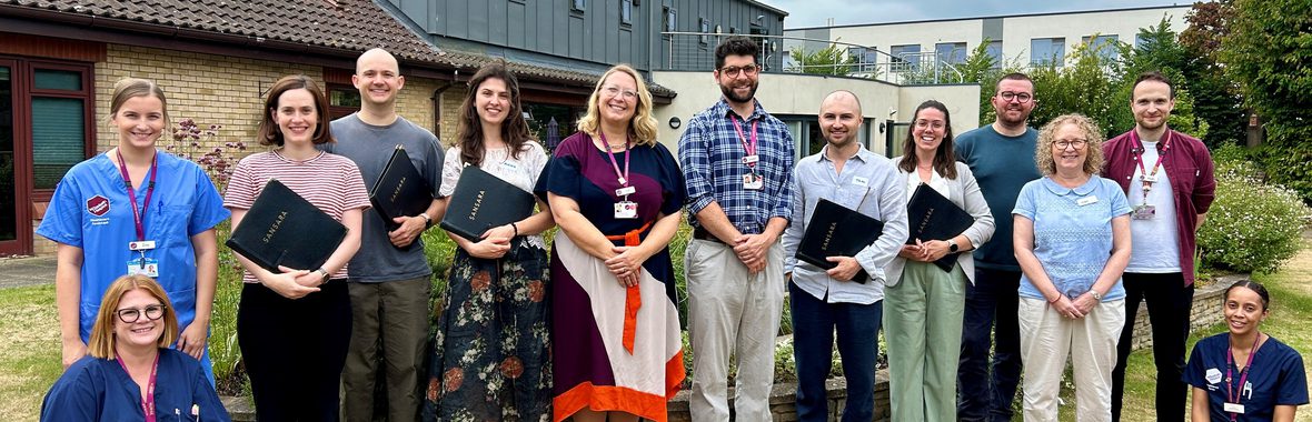 Sansara Choir group of men and women standing together in a row outside and smiling at the camera