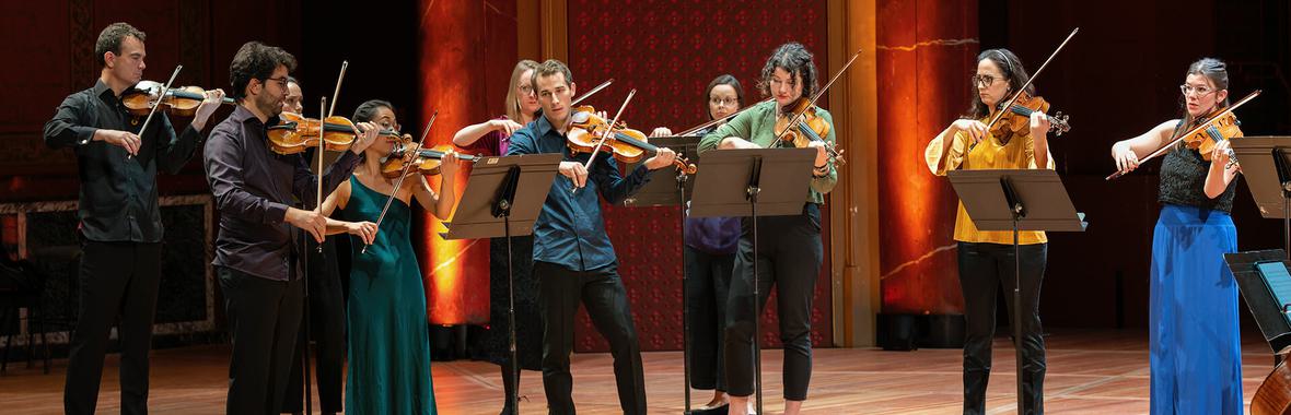 United Strings of Europe members standing and playing instruments on a wooden stage