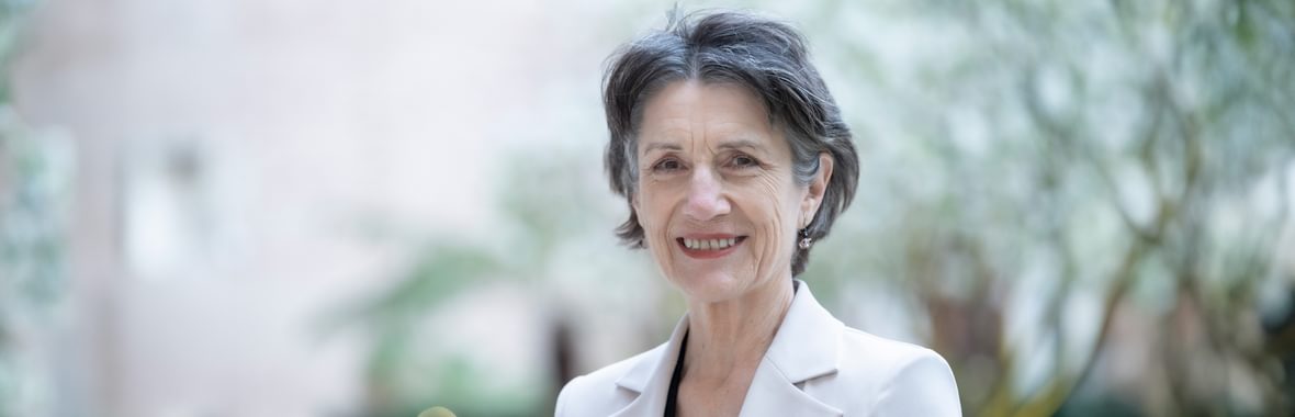 Close-up of Harriet Walter smiling against a background of trees