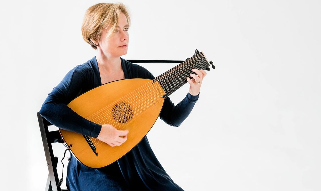 Liz Kenny seated and playing against a white background