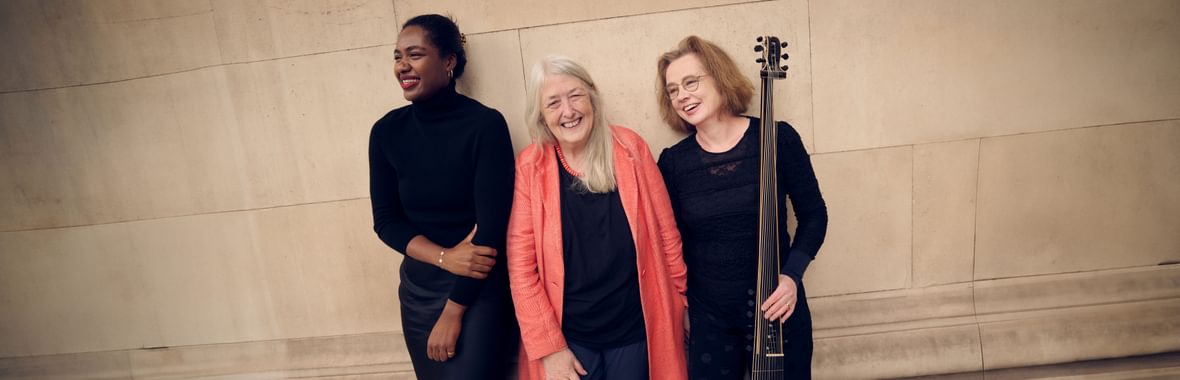 Nardus Trio standing and smiling against a stone panelled wall