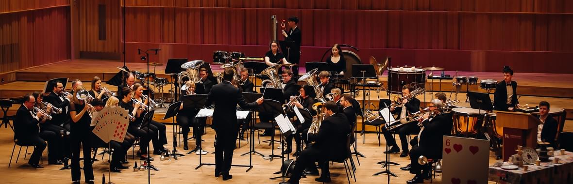 Brass band onstage with their conductor.