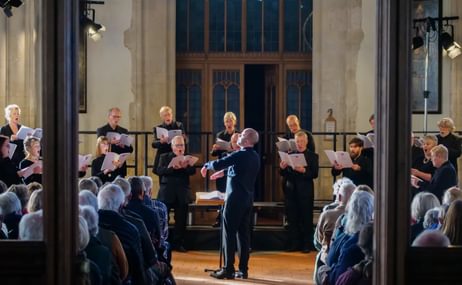 An audience watching a choir dressed in black