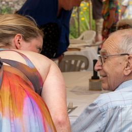 Caroline leaning over to talk to another person.