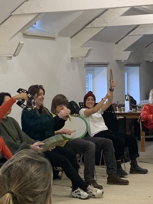 Group of people sitting and holding musical instruments in the air.